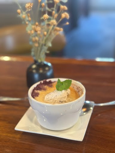 Berry cobbler with whipped cream at Our Thyme